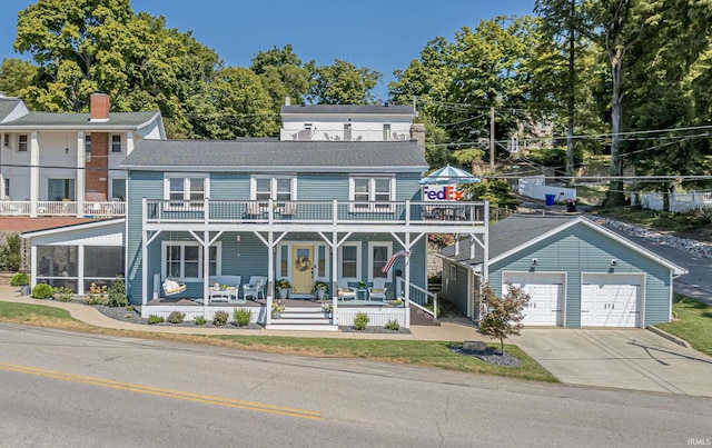 view of front facade featuring a balcony, a porch, and a garage