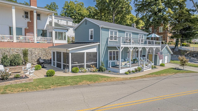 view of front of property with a garage, a sunroom, a patio area, a balcony, and covered porch