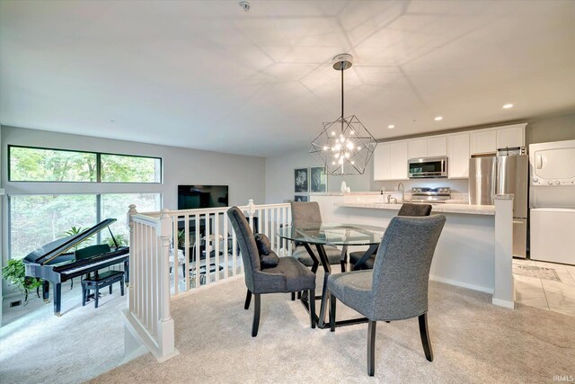 carpeted dining space with stacked washing maching and dryer, an inviting chandelier, and sink