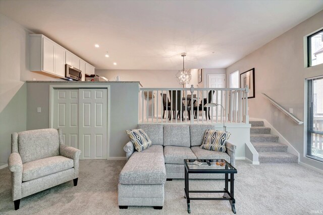 living room with light colored carpet and a notable chandelier