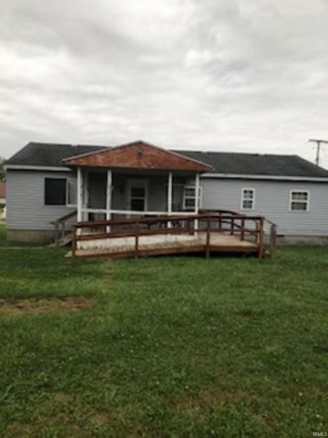 rear view of property with a deck and a yard