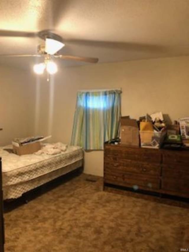 bedroom with ceiling fan and dark carpet