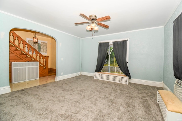 carpeted spare room with ceiling fan, ornamental molding, and radiator heating unit