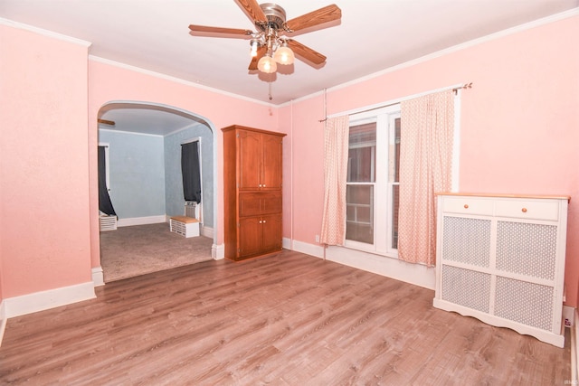 empty room with ceiling fan, crown molding, and hardwood / wood-style floors