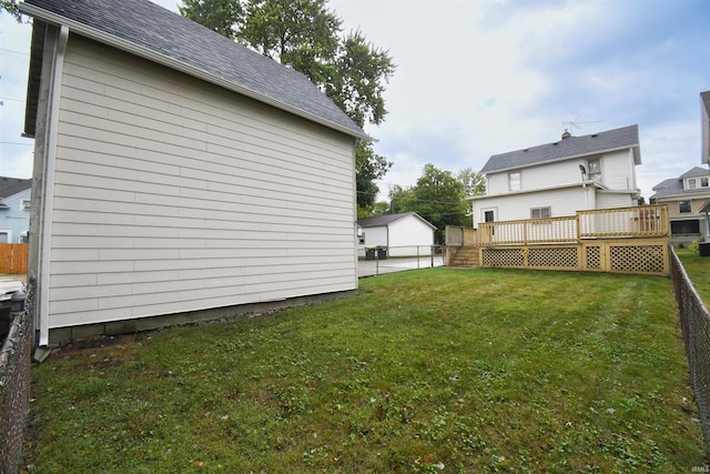 view of yard featuring an outdoor structure, a garage, and a deck