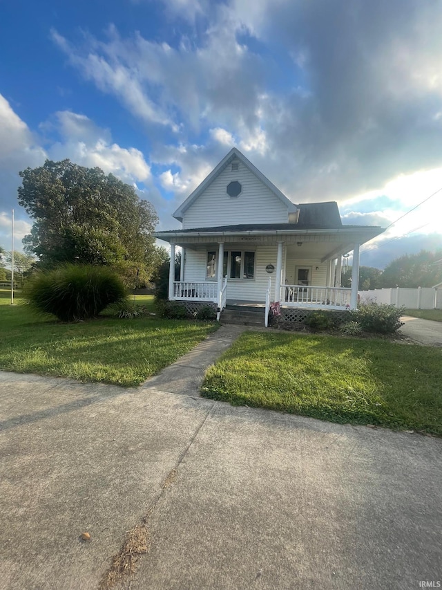 farmhouse inspired home with a front lawn and covered porch