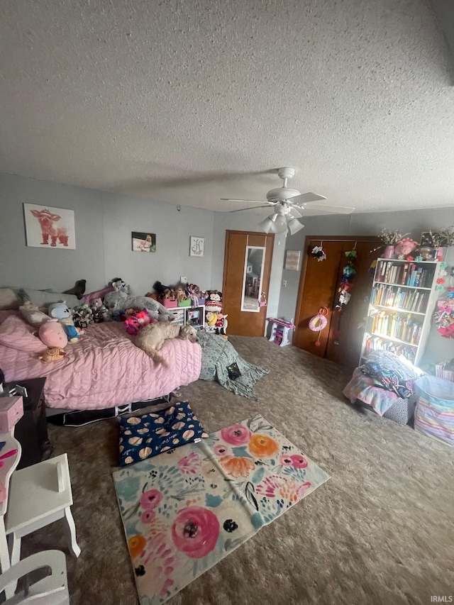 carpeted bedroom with ceiling fan and a textured ceiling