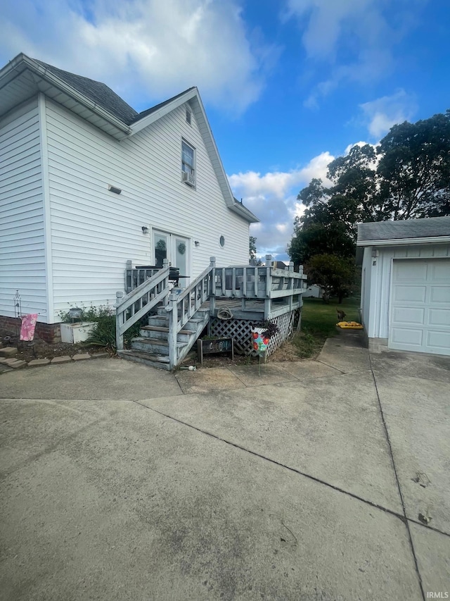 view of property exterior featuring a garage and a wooden deck