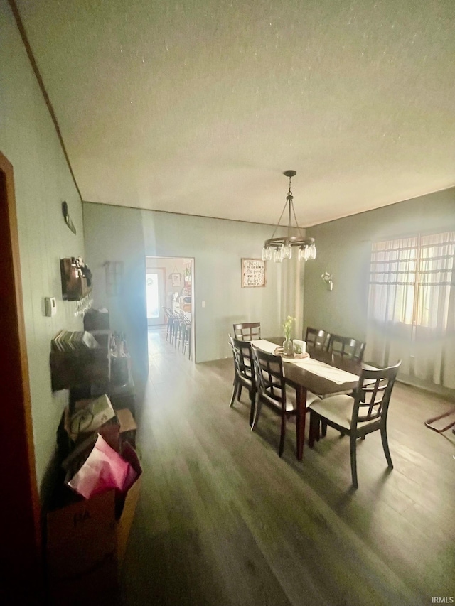 dining area featuring a textured ceiling, a healthy amount of sunlight, and a chandelier