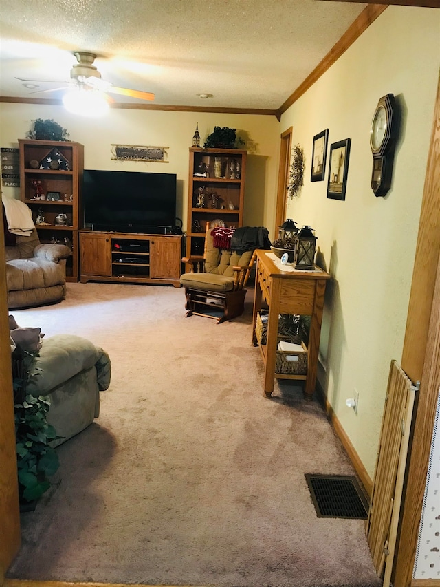 carpeted living room featuring ornamental molding, ceiling fan, and a textured ceiling