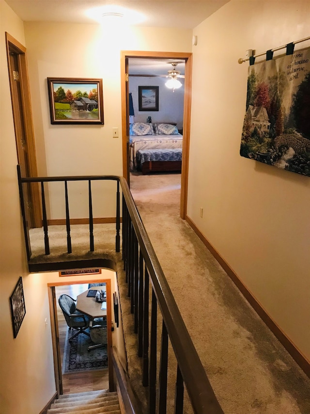 stairs with hardwood / wood-style floors and ceiling fan