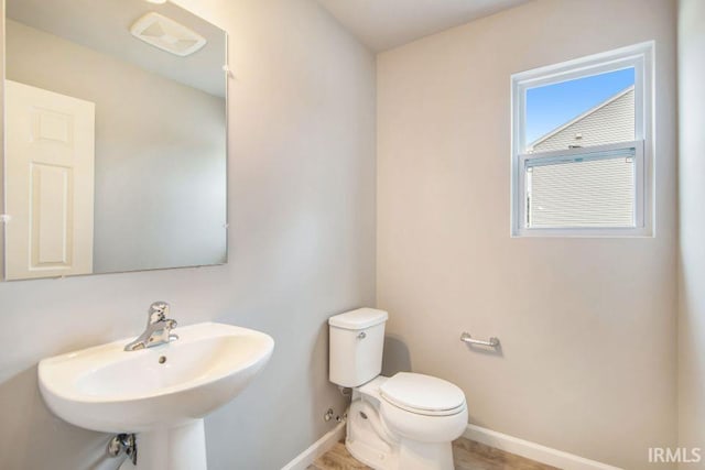 bathroom featuring toilet, hardwood / wood-style floors, and sink