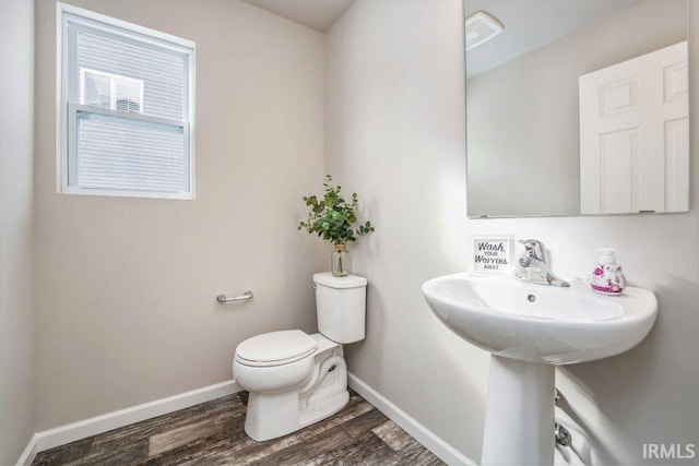 bathroom featuring hardwood / wood-style flooring and toilet