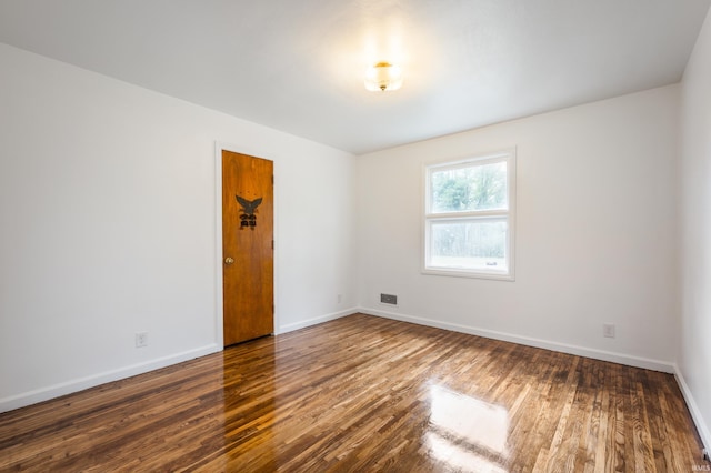 unfurnished room with dark hardwood / wood-style flooring