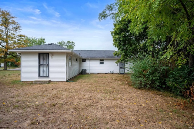 back of property featuring a yard and central air condition unit