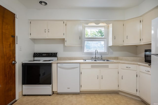 kitchen with sink, white appliances, and white cabinetry