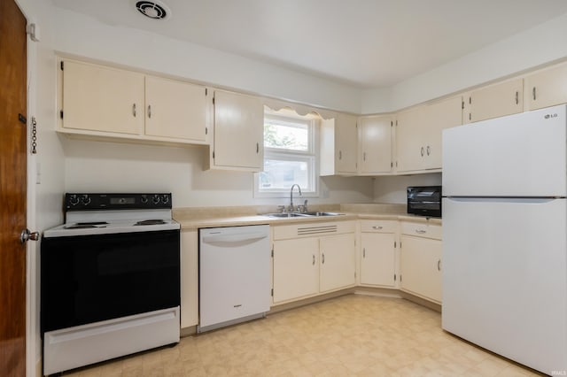 kitchen featuring cream cabinetry, white appliances, and sink