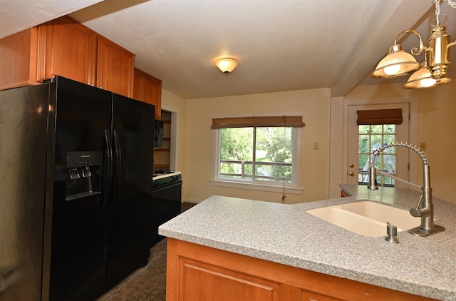 kitchen featuring dark tile patterned flooring, sink, a healthy amount of sunlight, and black appliances