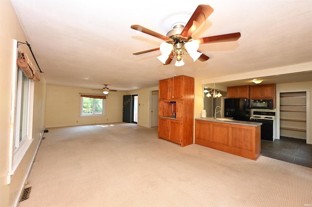 kitchen with sink, ceiling fan with notable chandelier, kitchen peninsula, light carpet, and black appliances