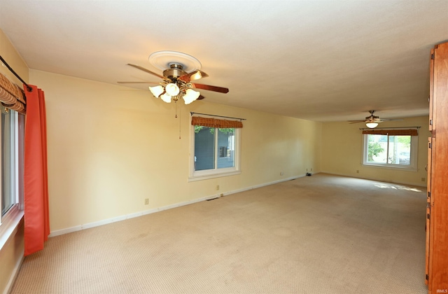 empty room featuring ceiling fan and light colored carpet