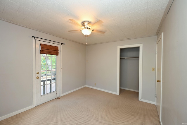 unfurnished bedroom featuring light carpet, ceiling fan, and a closet