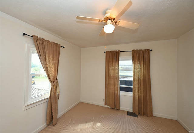 empty room featuring ceiling fan and carpet