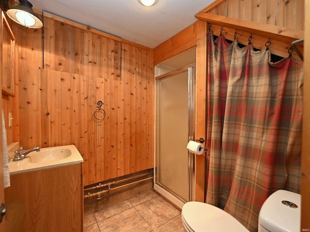 bathroom with vanity, walk in shower, wooden walls, toilet, and tile patterned floors