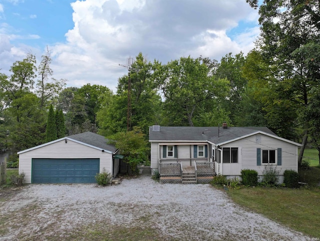 view of front facade featuring a garage, a deck, and an outbuilding