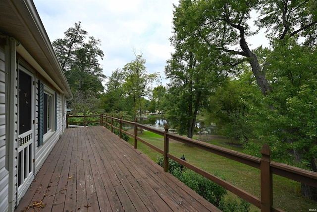 wooden deck with a lawn and a water view