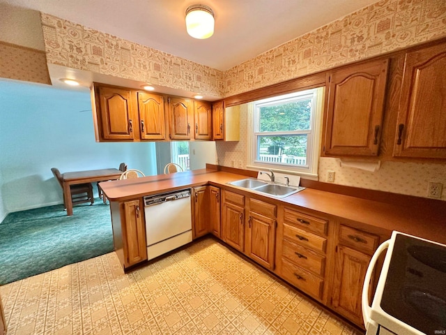 kitchen with sink, kitchen peninsula, range, dishwasher, and light colored carpet