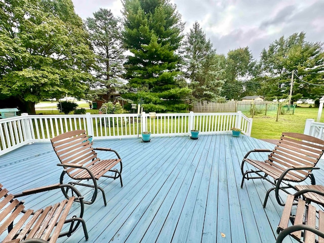 wooden deck featuring a lawn