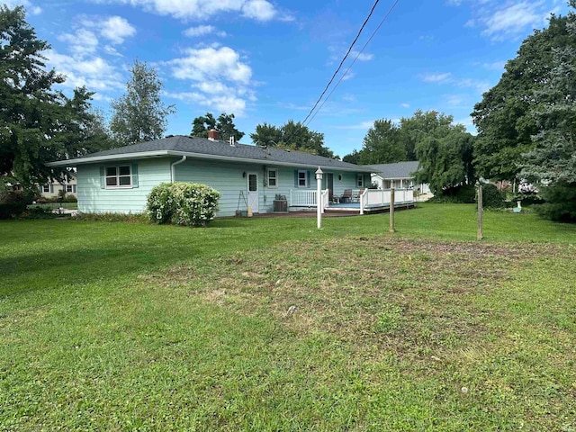 back of property with a yard and central AC