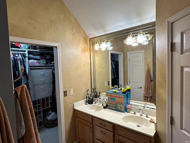 bathroom with lofted ceiling, a textured ceiling, and vanity