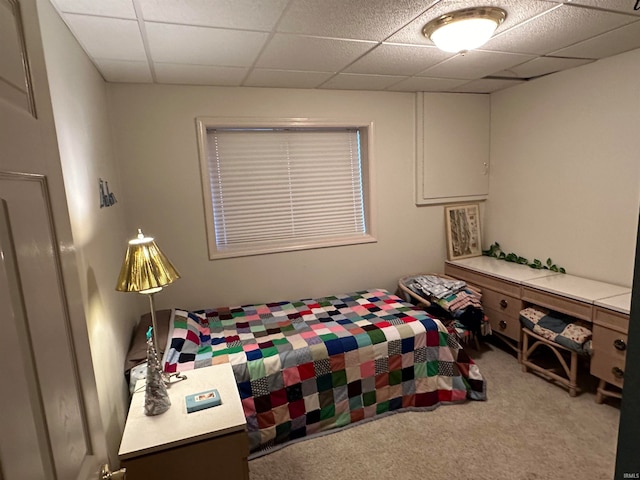 bedroom with carpet floors and a drop ceiling