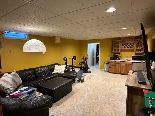 carpeted living room with wet bar and a drop ceiling