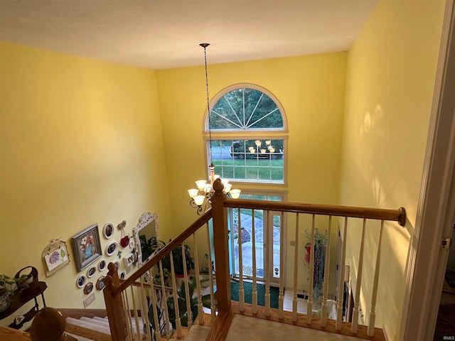 stairs with a notable chandelier