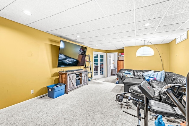 living room featuring french doors, a drop ceiling, and carpet