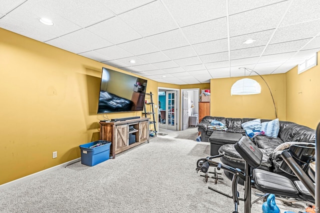 living room featuring carpet floors and a paneled ceiling