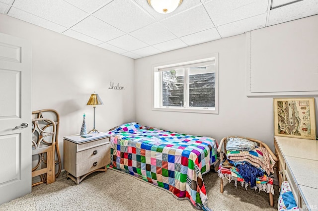 bedroom with a drop ceiling and carpet flooring