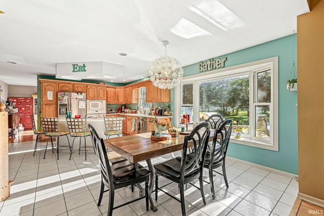 dining room with a notable chandelier, sink, and light tile patterned floors