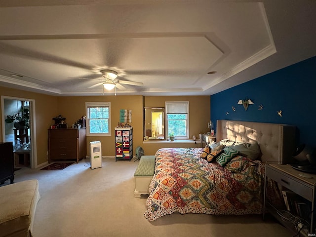 bedroom featuring ceiling fan, light colored carpet, a tray ceiling, and ornamental molding