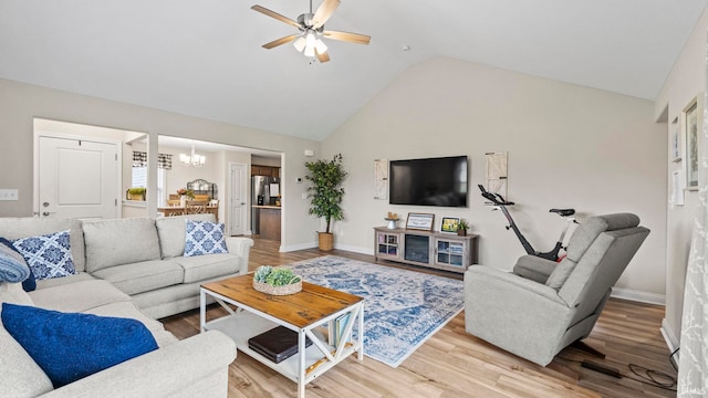 living room featuring high vaulted ceiling, baseboards, wood finished floors, and ceiling fan with notable chandelier