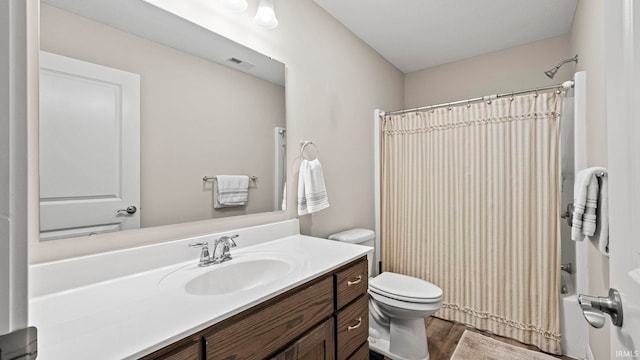 bathroom with wood finished floors, toilet, vanity, visible vents, and shower / tub combo with curtain