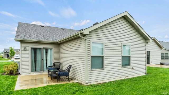 rear view of property with a yard and a patio area