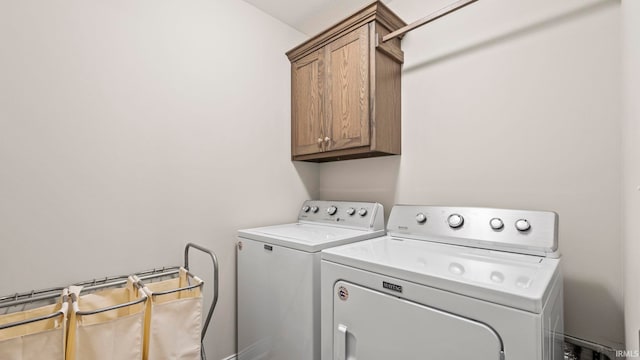 laundry room with washing machine and clothes dryer and cabinets