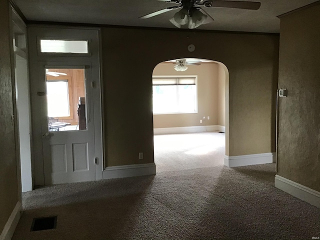 carpeted foyer featuring ceiling fan