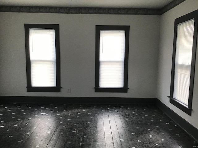 unfurnished room with dark hardwood / wood-style floors and a healthy amount of sunlight