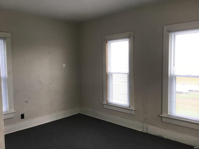 406 W 750 S, Star City, IN 46985 - empty room with healthy amount of natural light, dark colored carpet, and baseboards