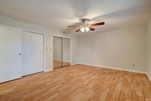 unfurnished bedroom featuring light wood-type flooring, ceiling fan, and multiple closets