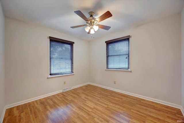 empty room featuring light hardwood / wood-style floors, ceiling fan, and a wealth of natural light